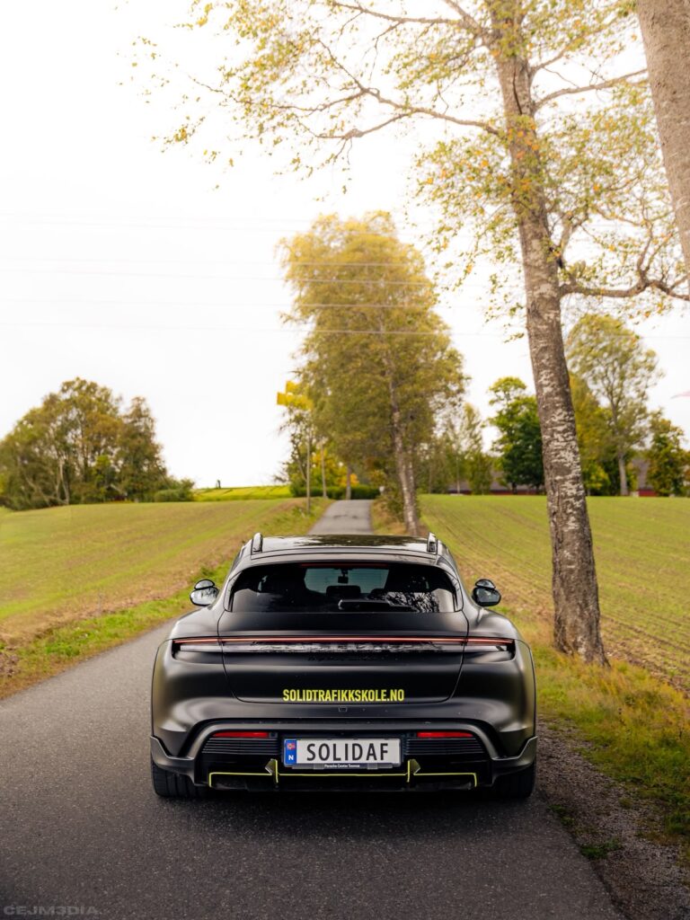 Porsche Taycan fra Solid Trafikkskole sett bakfra på bygdevei